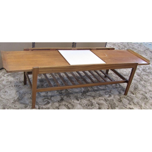 2305 - A retro teak low occasional table of rectangular form, the top with draw-leaves revealing a Formica ... 