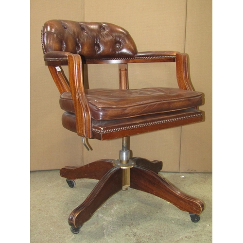 2317 - A reproduction swivel office desk chair with soft  tan leather upholstered pad seat, button back and... 