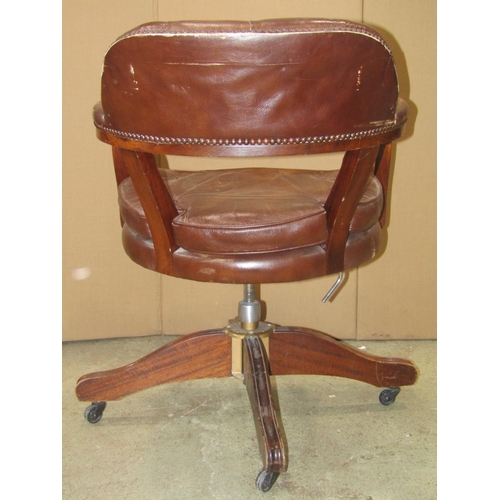 2317 - A reproduction swivel office desk chair with soft  tan leather upholstered pad seat, button back and... 