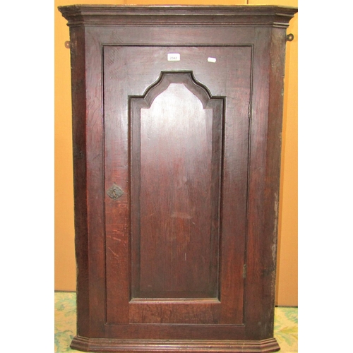 2342 - A Georgian oak hanging corner cupboard enclosed by a rectangular fielded arched moulded panelled doo... 