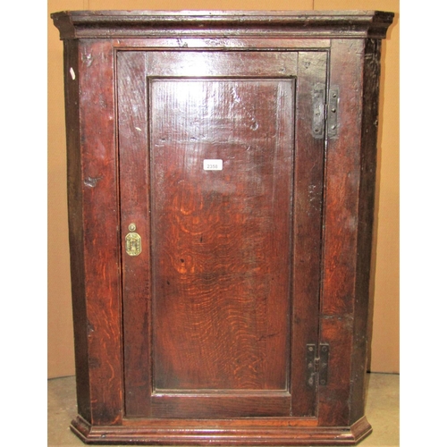 2358 - A Georgian oak hanging corner cupboard enclosed by a rectangular moulded panelled door with exposed ... 