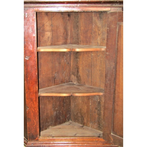 2358 - A Georgian oak hanging corner cupboard enclosed by a rectangular moulded panelled door with exposed ... 