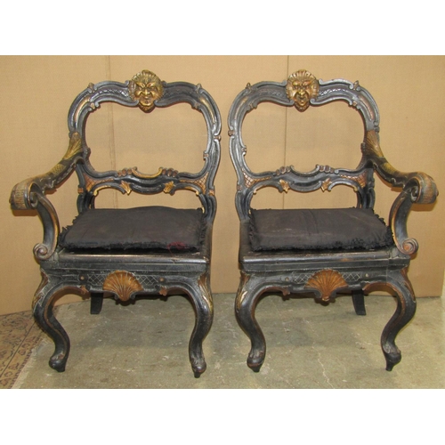 2382 - An unusual pair of low Victorian chairs with ebonised carved and scrolling moulded gilt highlighted ... 