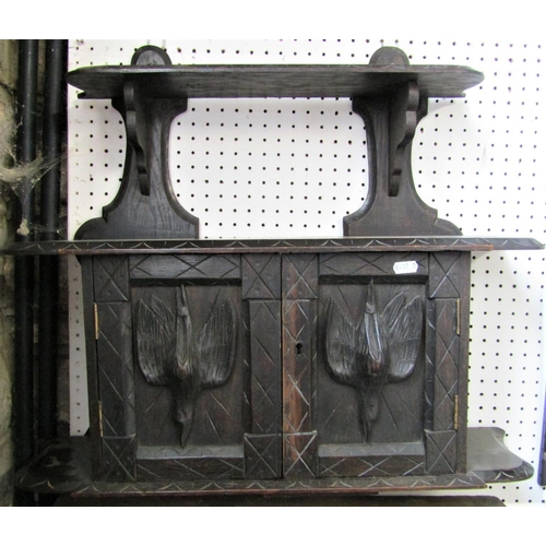 2384 - A Victorian dark stained carved oak wall hanging cupboard enclosed by a pair of panelled doors, with... 