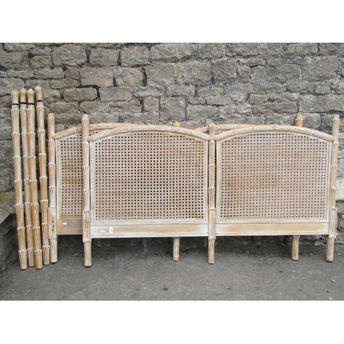 2400 - A double bedstead, the head and footboard enclosing arched double caned panels within decorative rep... 