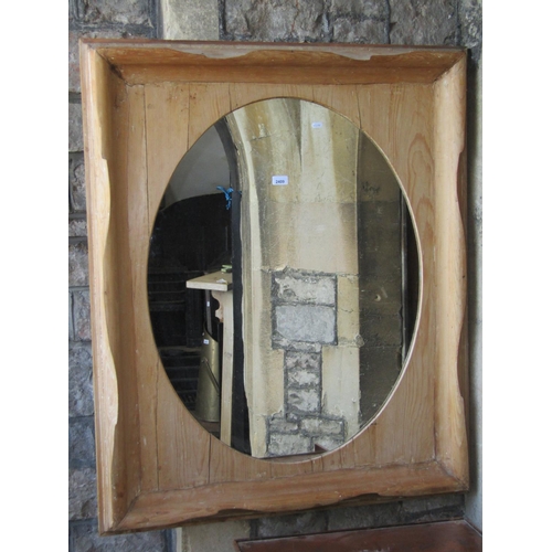 2409 - A large wall mirror, the oval plate set within a swept and moulded stripped pine frame, 98cm wide x ... 