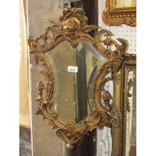 2410 - A small shield shaped wall mirror with bevelled edge plate within a scrolling gilt acanthus frame wi... 