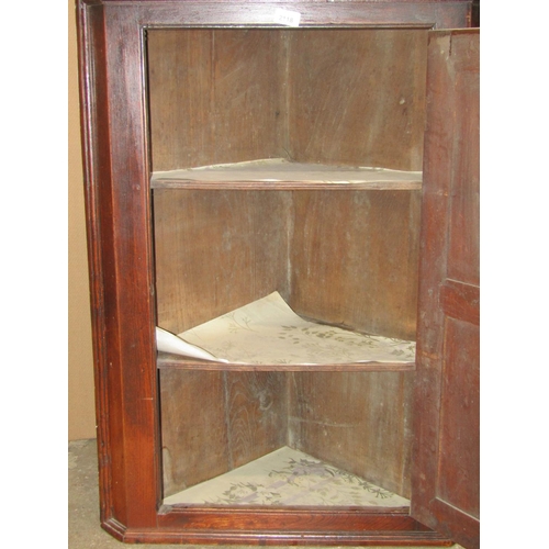 2118 - A Georgian countrymade hanging corner cupboard enclosed by a single twin moulded panelled door, with... 