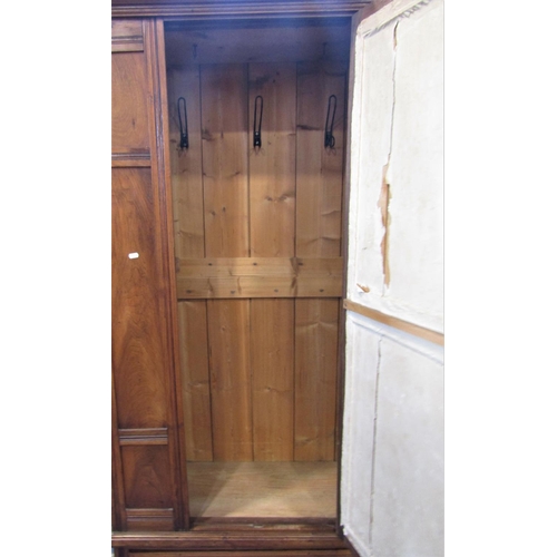 2117 - An Edwardian walnut single wardrobe, the moulded panelled front enclosed by a central three quarter ... 