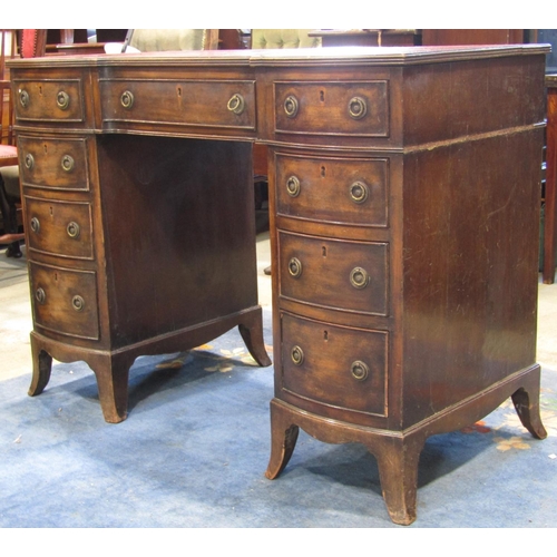 2353 - A Georgian style kneehole three sectional twin pedestal desk with serpentine front and inset leather... 