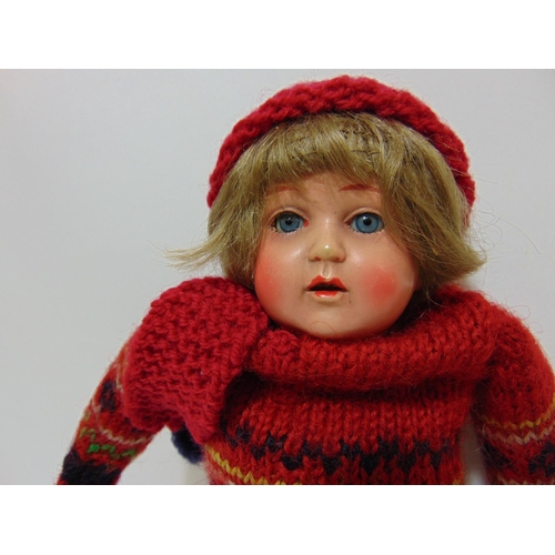 75 - Early 20th century celluloid shoulder head doll with blue closing eyes and cloth body wearing knitte... 