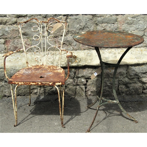 2064 - A small vintage and weathered green painted ironwork garden table with circular tin top, raised on s... 