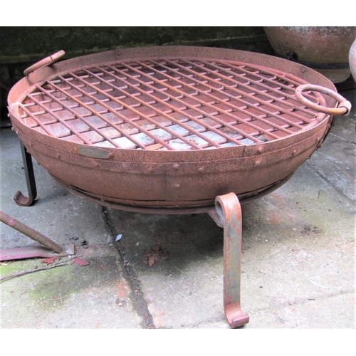 2070 - A weathered/used ironwork banded fire bowl and stand, with drop ring handles and applied label 'Scum... 