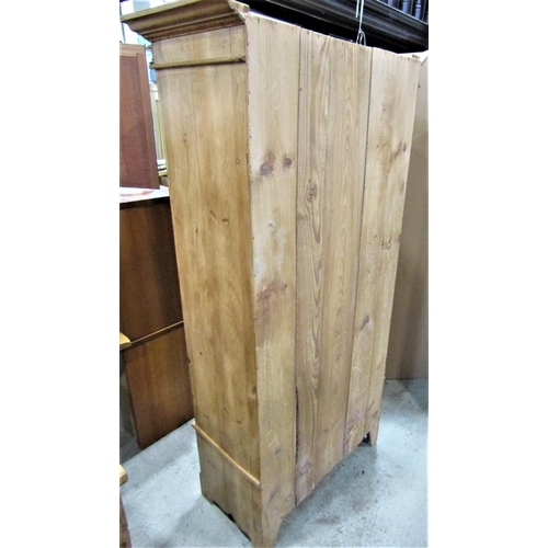 2327 - A Victorian stripped pine single wardrobe with fixed moulded cornice over a central three quarter le... 