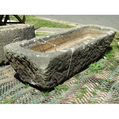 2131 - A weathered granite trough of rectangular form with rounded corners and single drainage hole, 121 cm... 