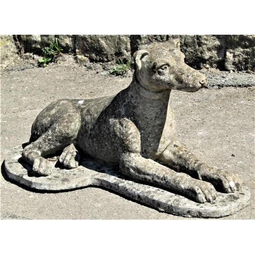 2148 - A well weathered reclaimed garden ornament in the form of a recumbent whippet with shaped platform b... 