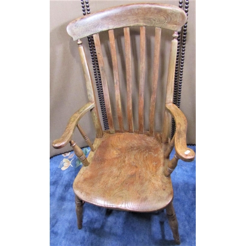 2284 - A Windsor elm and beechwood lathe back arm chair with wide generous saddle shaped seat raised on spl... 