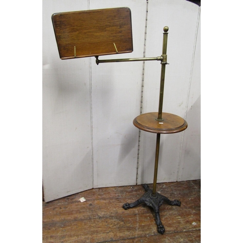 2829 - A Victorian reading stand with cast iron base, lions paw feet, the brass column supporting a circula... 