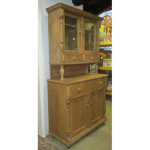 2241 - A stripped pine two sectional kitchen dresser, enclosed by four doors (the upper glazed) and three d... 