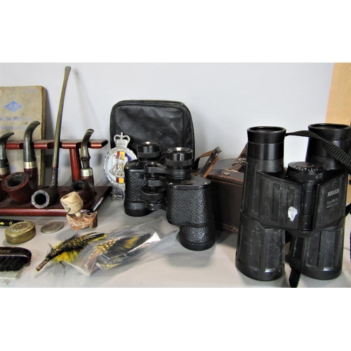 700 - A box of miscellaneous items to include a collection of pipes, binoculars, pin badges, etc