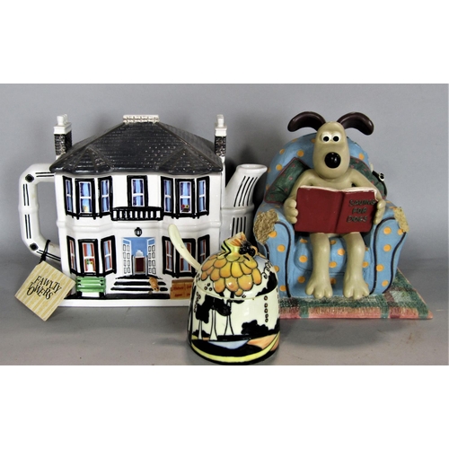 708 - A mixed novelty lot to include a novelty tea pot in the form of Fawlty Towers, a Wallace and Gromit ... 