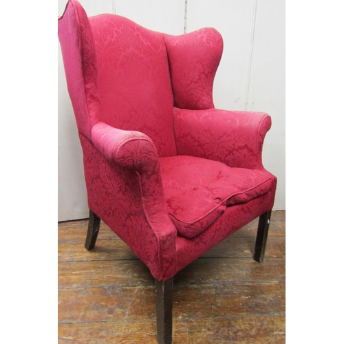 2783 - A Georgian wing chair with scrolled arms, raised on square cut supports