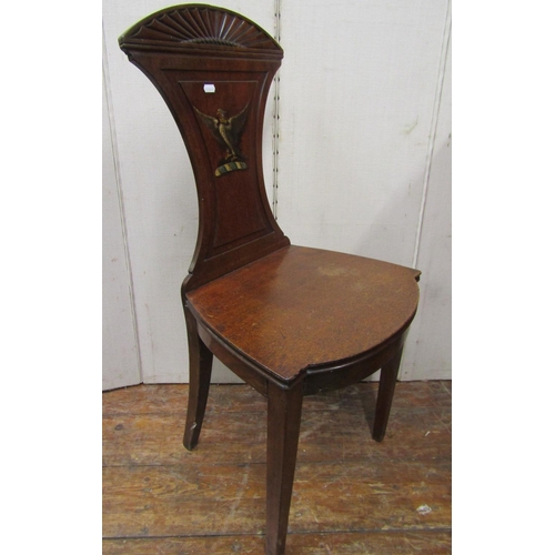 2788 - A Georgian mahogany hall chair with solid seat, the shaped back with armorial crest of an eagle with... 