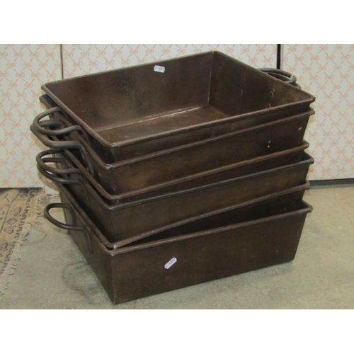 2251 - A stack of six industrial steel rectangular trays, with fixed loop handles