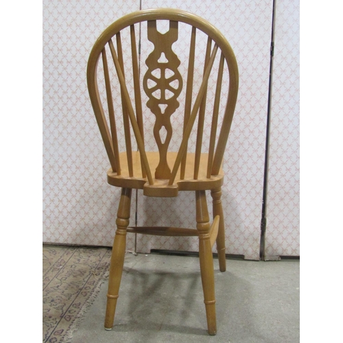 2256 - A set of eight modern beechwood Windsor hoop and stick back dining chairs with central pierced wheel... 