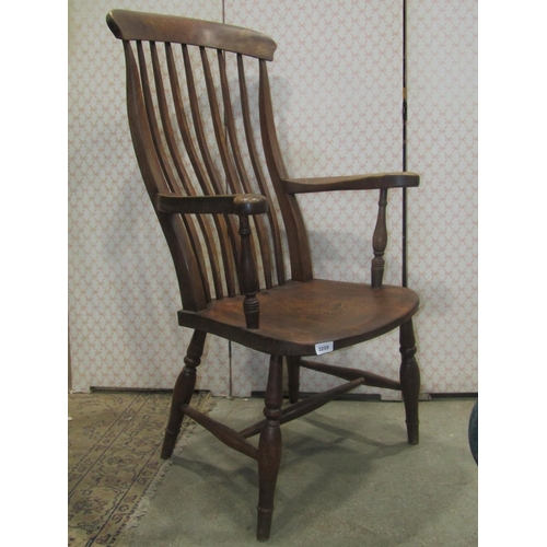 2259 - A Windsor stained elm and beechwood slender and curved lathe back open arm chair in elm and beech, r... 