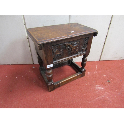 2794 - An Old English oak box stool with rising lid, with carved detail and turned supports