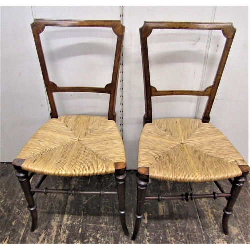 2799 - A pair of Victorian walnut side chairs with rush seats on swept supports and rails