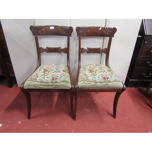 2831 - A pair of Regency flamed mahogany sabre legged side chairs with carved detail and hand worked tapest... 