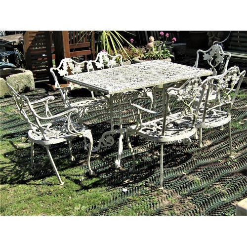 2104 - A cream painted cast aluminium garden terrace table of rectangular form with decorative pierced foli... 