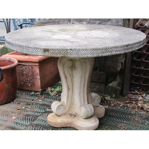 2217 - A reclaimed garden table, the circular top with foliate detail and chevron border, raised on a scrol... 