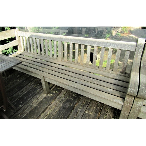 68 - A good quality weathered teak garden bench, 240cm wide