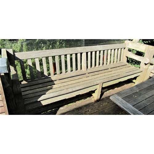 69 - A good quality weathered teak garden bench, 240cm wide