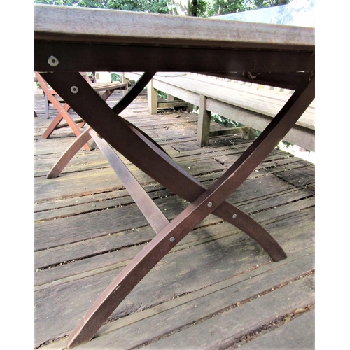 71 - A good quality weathered teak garden table with slatted top and folding x shaped frame, 155cm x 95cm... 