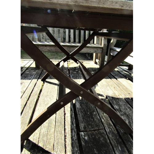 72 - A good quality weathered teak garden table with slatted top and folding x shaped frame, 155cm x 95cm... 