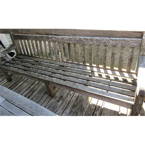 76 - A good quality weathered teak garden bench, 240cm long