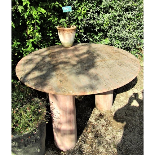 79 - A circular garden table with weathered marble finish, the 120cm diameter top raised on three column ... 