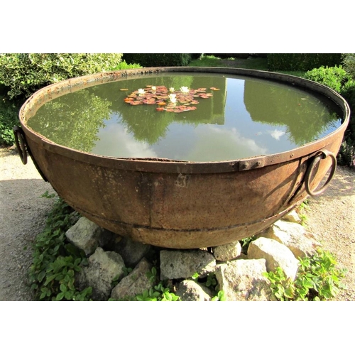 82 - A massive riveted iron cauldron with ring handles (water tight) 170cm diameter