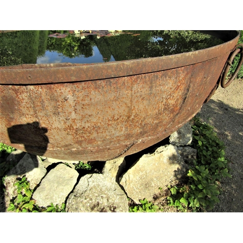 82 - A massive riveted iron cauldron with ring handles (water tight) 170cm diameter