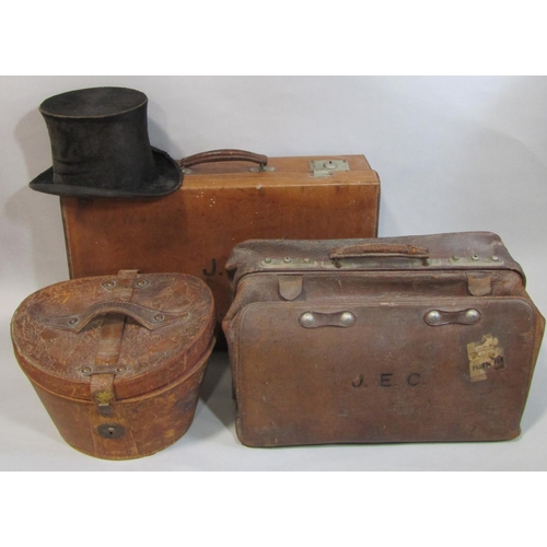 495 - Black silk top hat (AF) in velvet lined leather hat box together with a leather suitcase with fitted... 