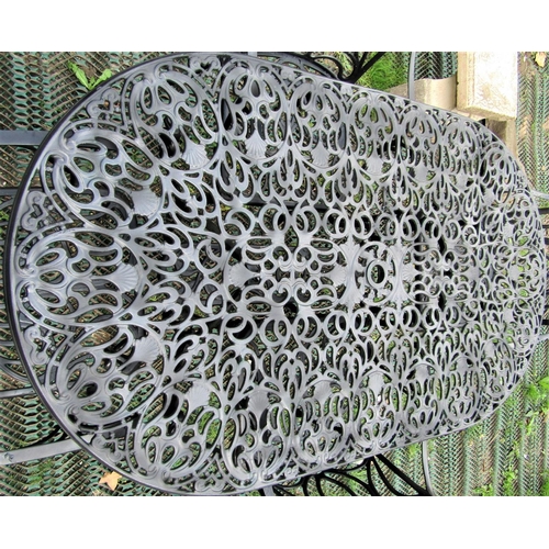 1574 - A contemporary cast aluminium garden terrace table of oval form with decorative pierced foliate scro... 