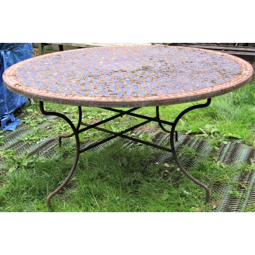 1563 - A weathered Moroccan garden table, the circular mosaic and wriggle pattern entwined lattice top with... 