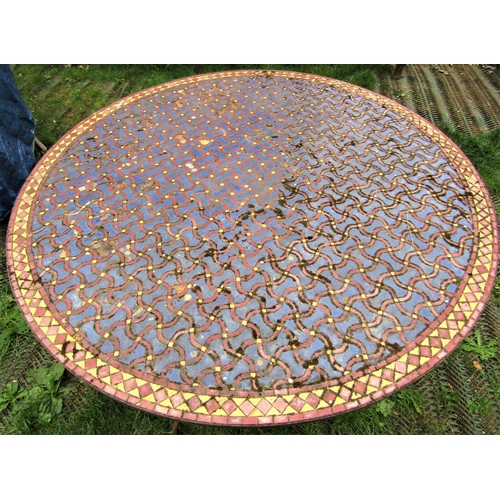 1563 - A weathered Moroccan garden table, the circular mosaic and wriggle pattern entwined lattice top with... 