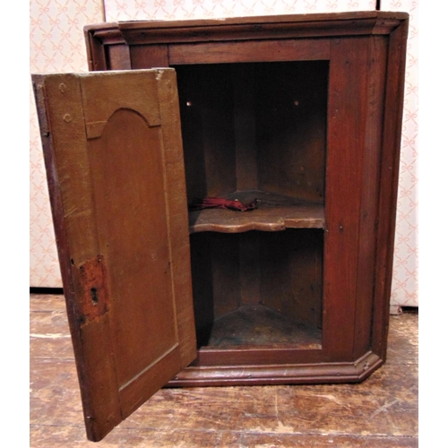 2144 - A small Georgian country made hanging corner cupboard in mixed woods, mainly elm, enclosed by an arc... 