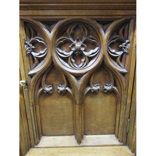 2150 - A Victorian oak cabinet with Gothic tracery detail, enclosed by a single door with further applied m... 