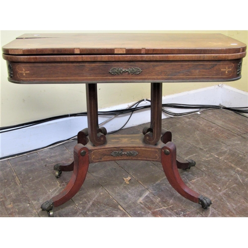 2157 - A Regency rosewood foldover top card table raised on four scrolled supports and platform base, with ... 